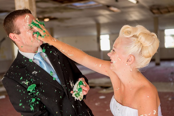 bride smashes wedding cake in grooms face